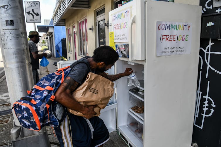 People taking free food from a community refrigerator.