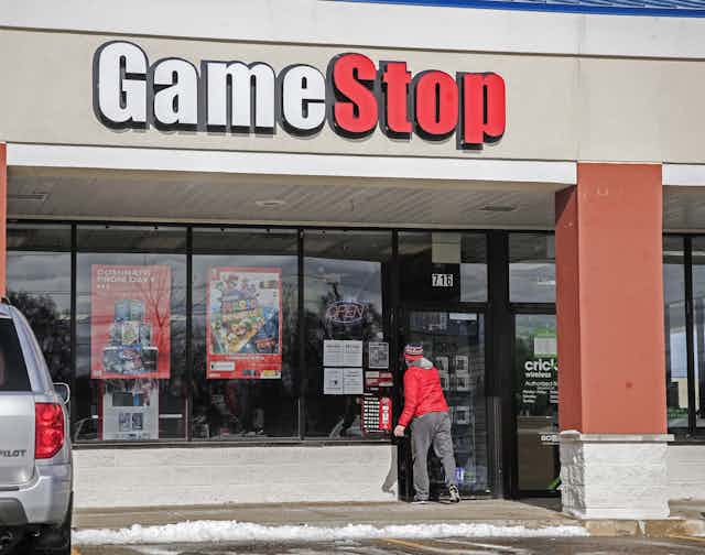 A man walking into a GameStop store.