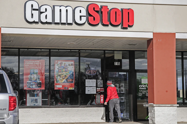 A man walking into a GameStop store.