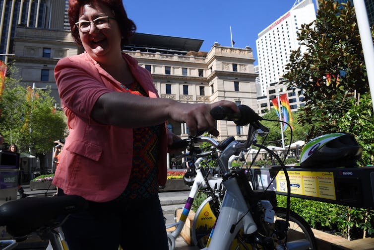 Women takes an e-bike from a stand