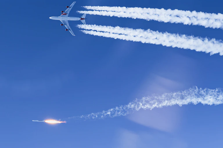 A rocket and a plane next to each other in the sky.