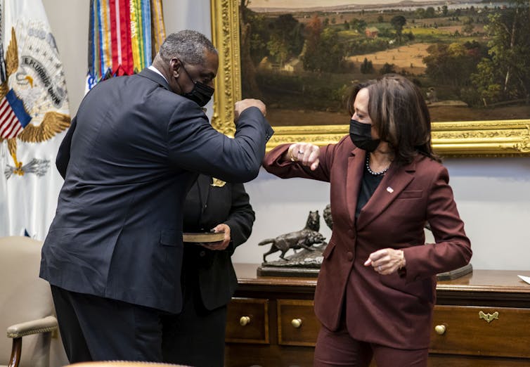 Vice President Kamala Harris and Secretary of Defense Lloyd Austin elbow bump.