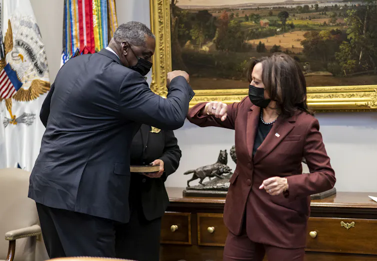 Vice President Kamala Harris and Secretary of Defense Lloyd Austin elbow bump.