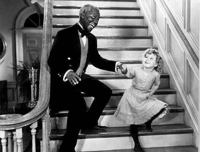Bill and Shirley dancing on a staircase. 