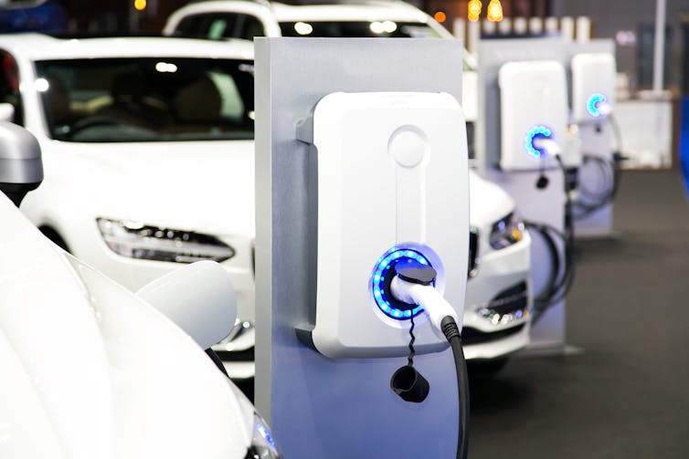 Voiture électrique blanche branchée sur un chargeur