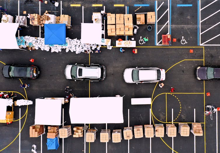 An aerial view shows volunteers loading cars with turkeys and other food.