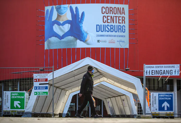 A man walks past a coronavirus vaccine distribution centre.