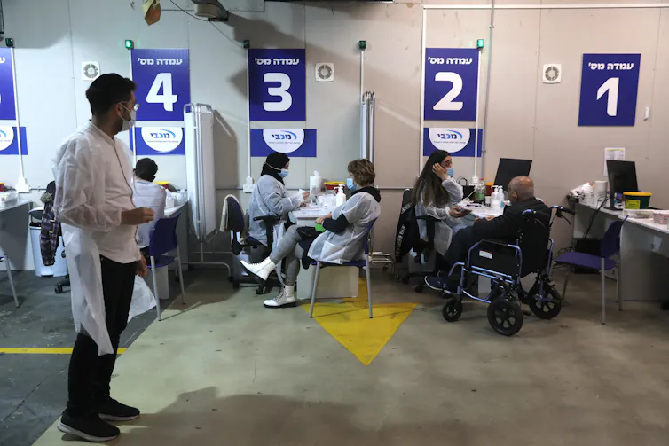 People wait at a coroanvirus vaccination centre in Israel