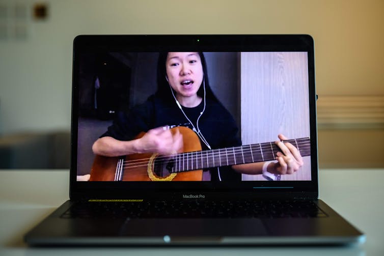 A woman playing a guitar on social media.