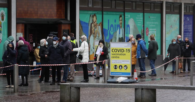 People wait in line for vaccine.