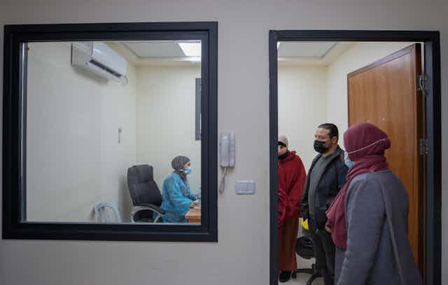 A medical staffer registers Palestinian patients infected with COVID-19 at the emergency unit, in the Palestine Medical Complex, in the West Bank city of Ramallah,