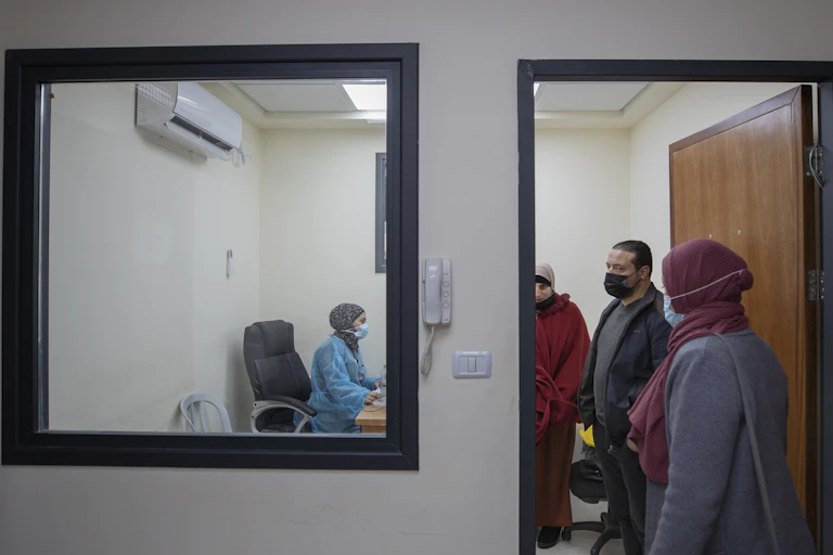 A medical staffer registers Palestinian patients infected with COVID-19 at the emergency unit, in the Palestine Medical Complex, in the West Bank city of Ramallah,