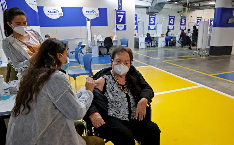 A health worker administers a coronavirus vaccine inside a parking garage in Tel Aviv.