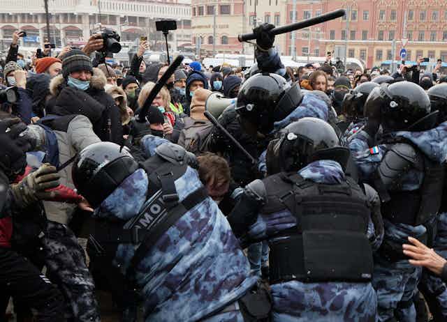 Police accosting pro-Navalny protesters.