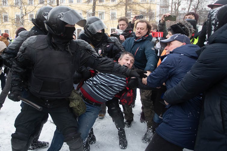 Riot police dragging a protester away in St. Petersburg, Russia.