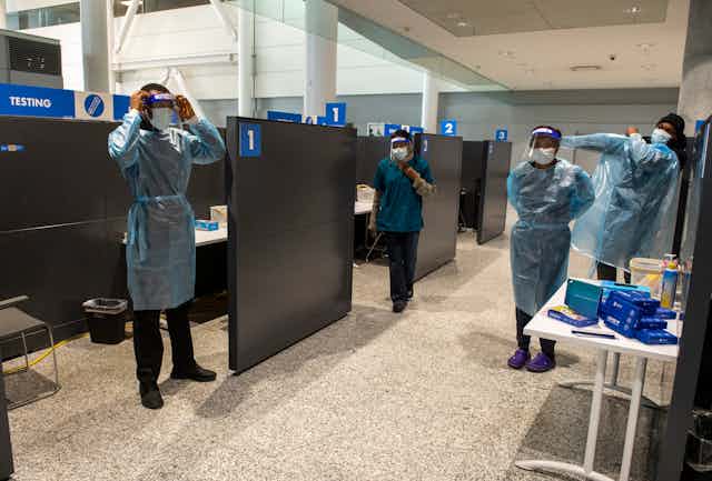 Workers at Pearson Airport put on protective gear