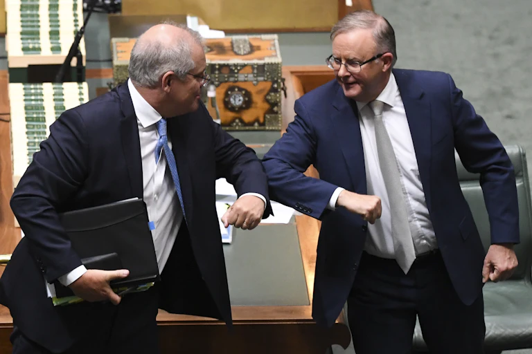 Scott Morrison and Anthony Albanese nudge elbows together in parliament.