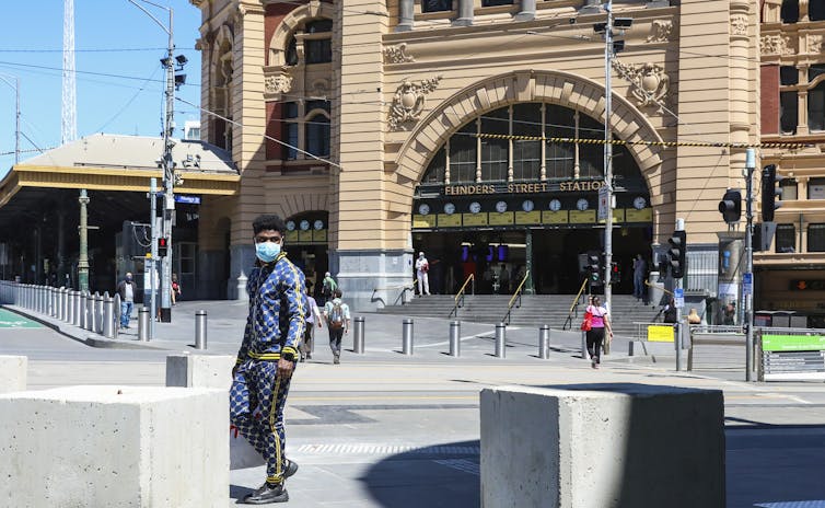 A handful of people outside Flinders Street Station in Melbourne.