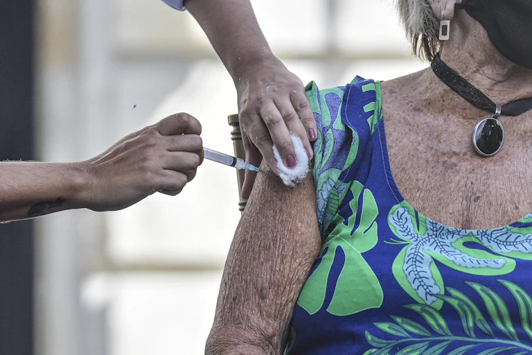 An elderly woman receives the vaccine in Brazil.
