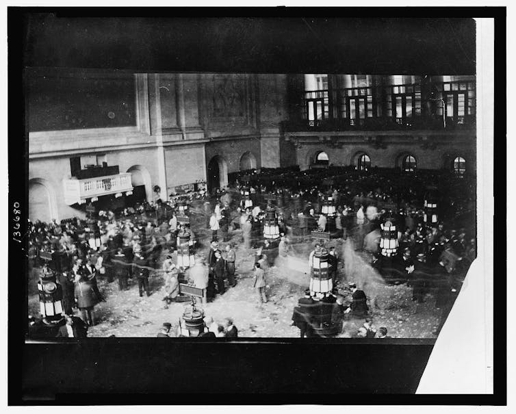 Black and white bustling photo of the floor of the New York Stock Exchange,