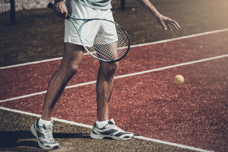 An unknown tennis player shown only from chest down.