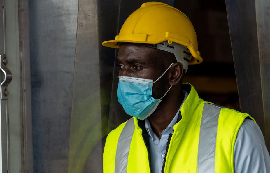 Factory industry worker working with face mask to prevent Covid-19 Coronavirus spreading during job reopening period .