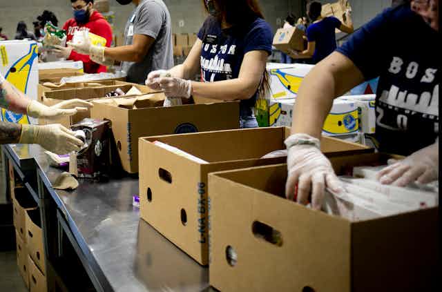 People load food into cardboard cartons