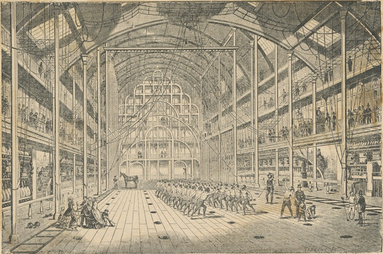 People exercise in the high-ceilinged gymnasium.