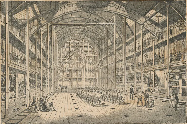 People exercise in the high-ceilinged gymnasium.