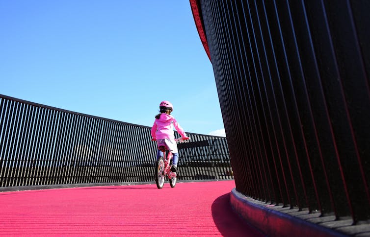 Child riding a bike along a cycle way