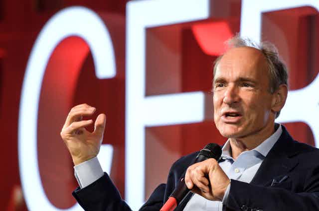 Tim Berners-Lee speaking with a microphone at a CERN meeting