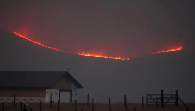 Flames rise from mountain ridges.