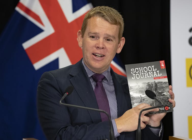 Chris Hipkins holding a school journal