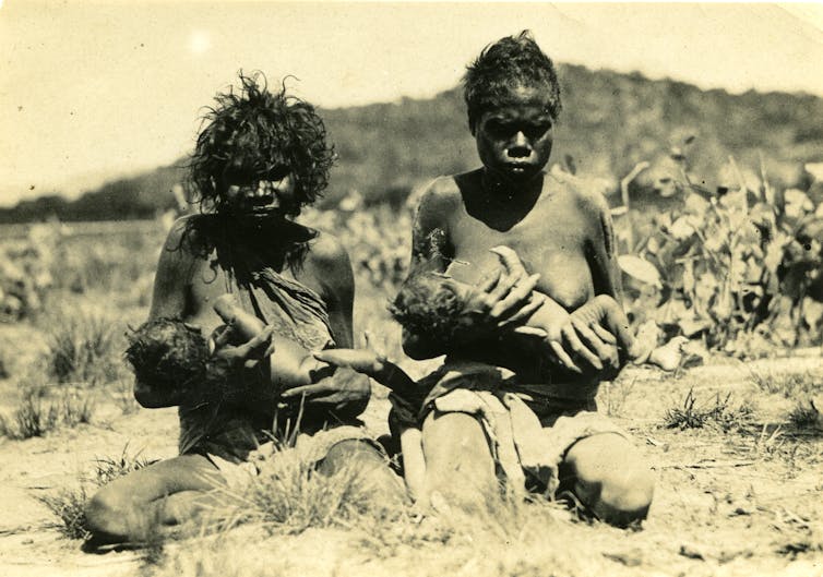 Gurrhwek Mangiru (left) with baby Gurrhwek Mangiru (left) Albert Balmana, and unidentified woman and baby (right), Oenpelli, Northern Territory Archives Service.