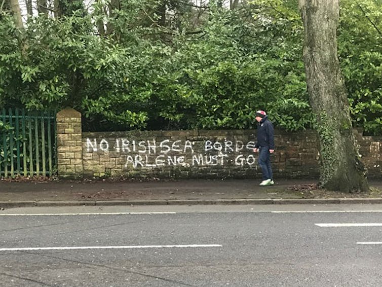 Graffiti on a wall reading 'No Irish Sea border Arlene must go'.