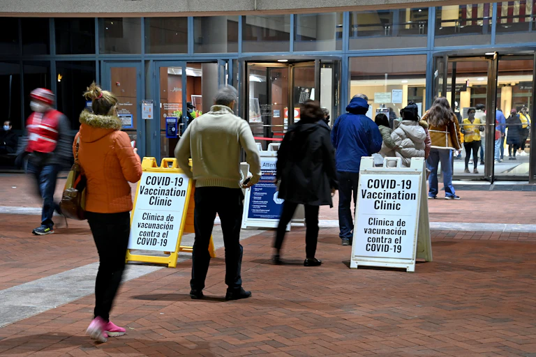 People stand in line for COVID-19 vaccines in Fairfax, Virginia.
