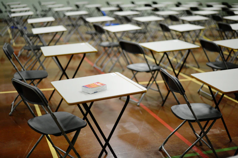 Empty chairs and desks in an exam hall.