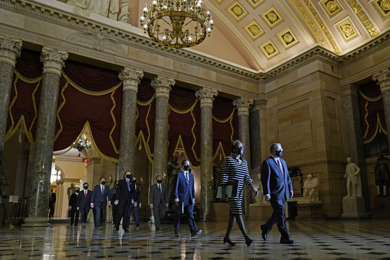 A group walks the article of impeachment through the Capitol