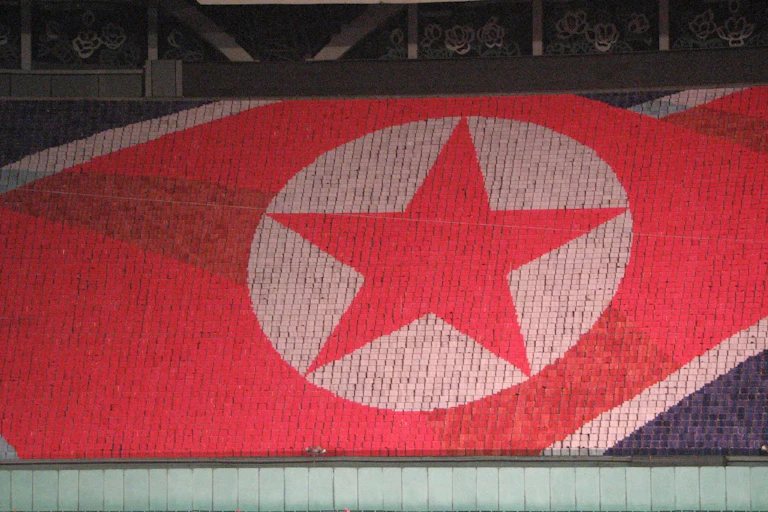 the North Korean flag formed by people in a stadium holding colored cards