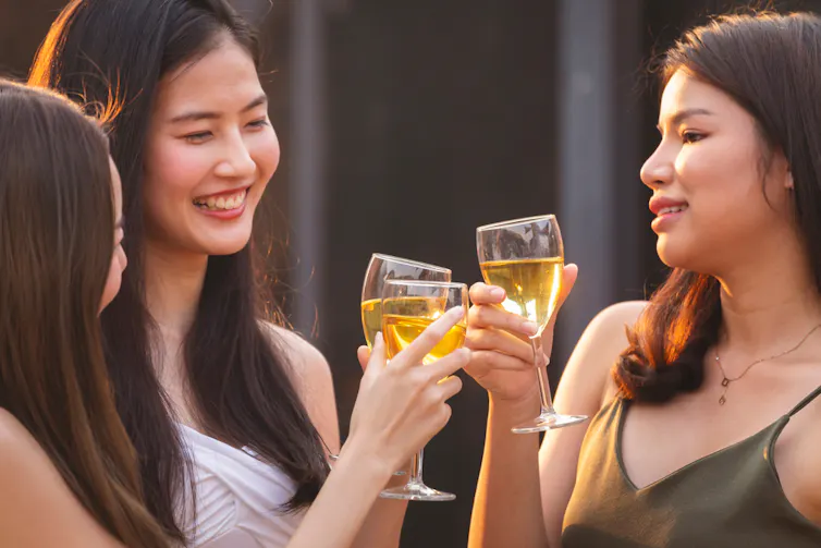 Three young people drinking wine