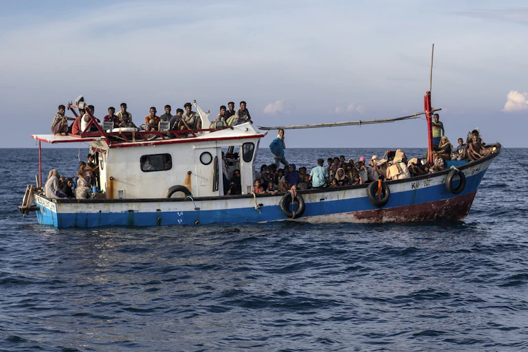 Rohingya Muslims sit on a a wooden boat adrift on the water off Lhoksukon, Aceh, Indonesia, in June 2020.