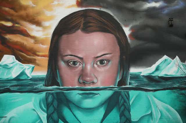 A mural depicts Greta Thunberg submerged amid ice floes.