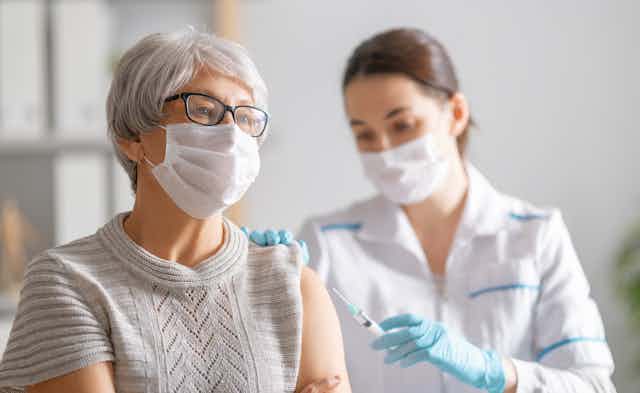 A nurse vaccinating a woman