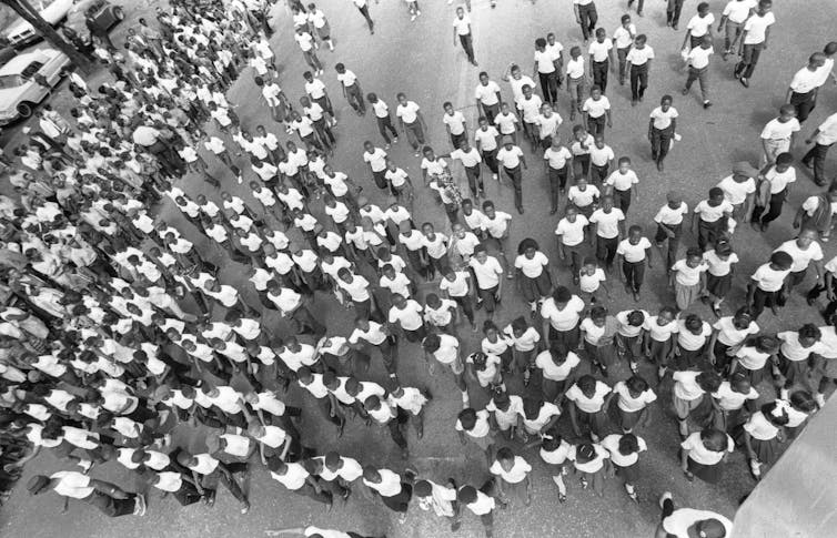 A birds-eye view of a throng of kids marching in the parade.