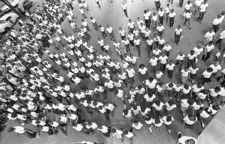 A birds-eye view of a throng of kids marching in the parade.