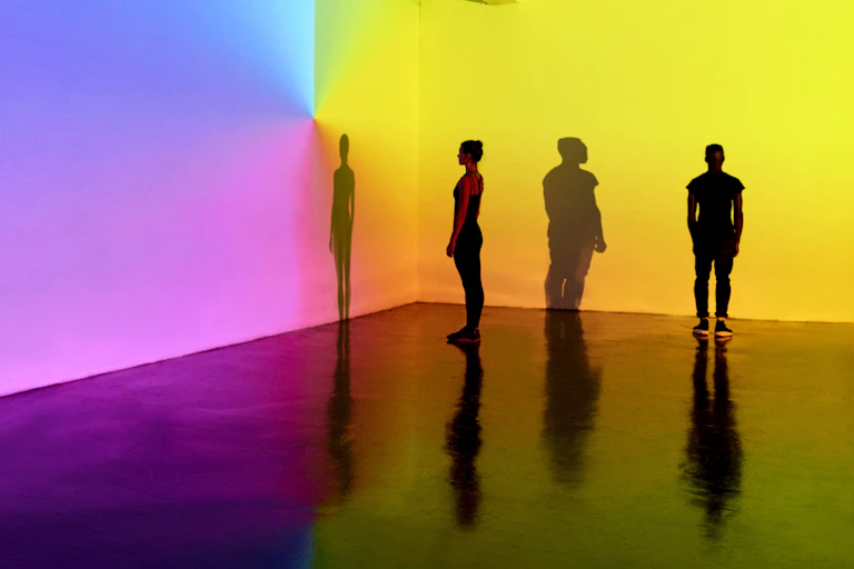 people standing in front of color projections on wall