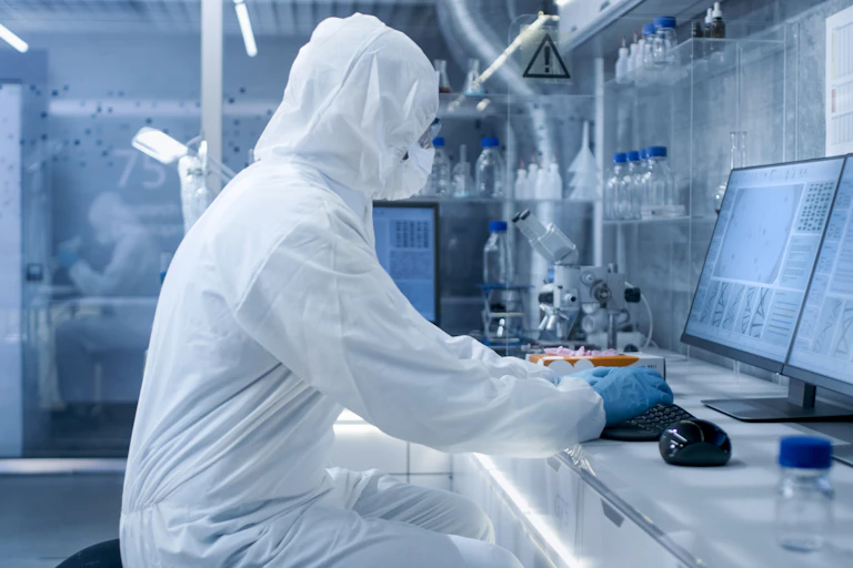 A scientists in PPE working in a lab