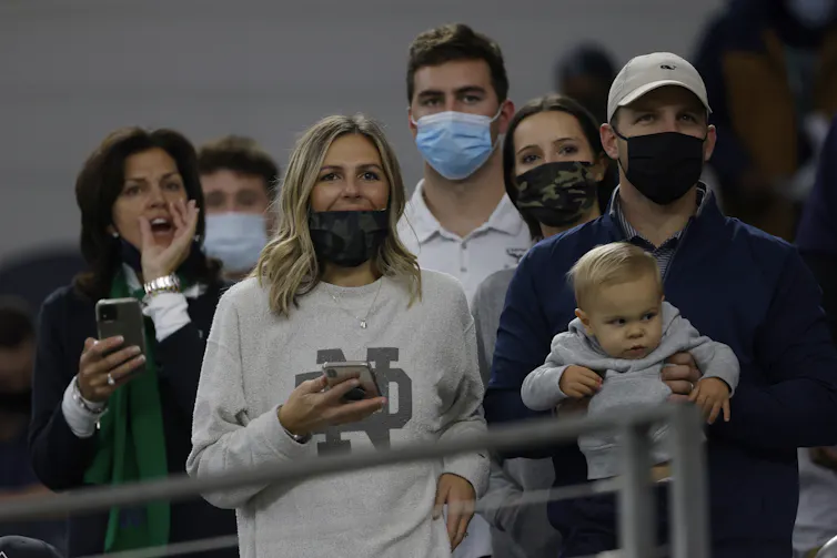 People standing close together, most wearing masks.