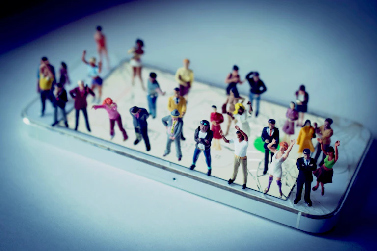 Miniature people standing on a smartphone