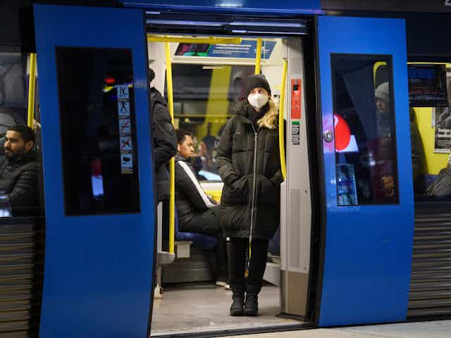 A woman wears a mask on a stockholm train.